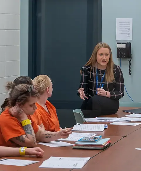 A woman instructs a group of female inmates at the local jail.